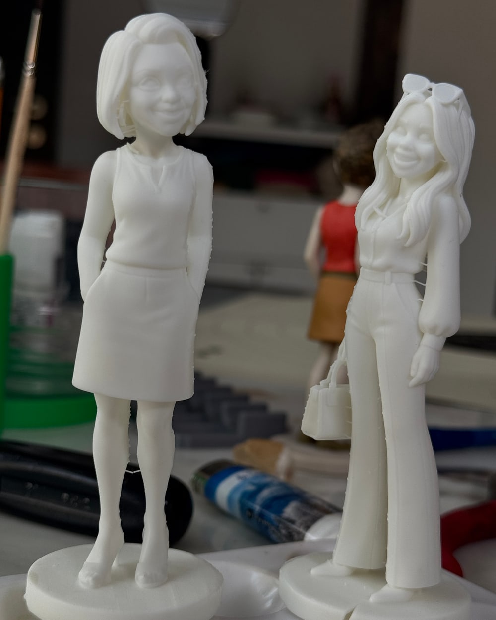 Deux figurines L'Épure, en résine blanche, sorties de l'atelier